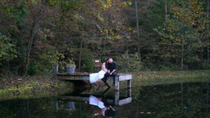 Wedding couple sitting on pond pear