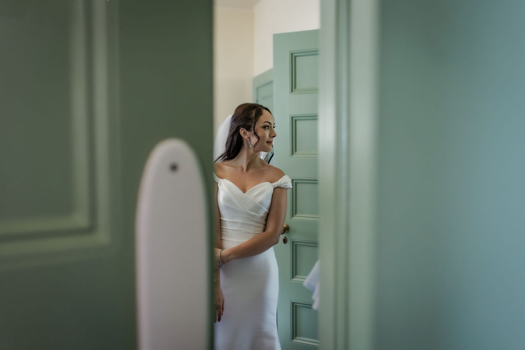 peeking through a door of a bride getting ready for her wedding at newfields indianapolis