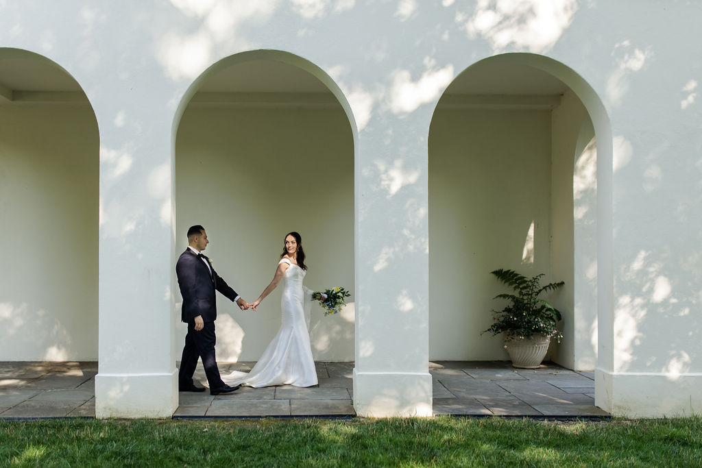 bride and groom newly wed walking behind estate in indianapolis