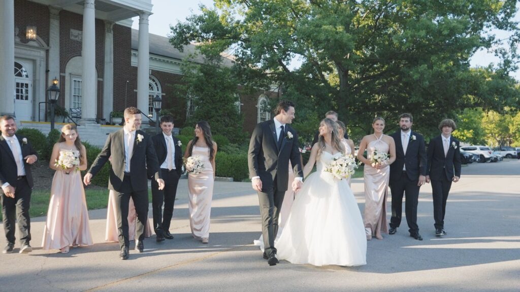 Star and Zach with bridal party walking away from The Olmsted Venue.