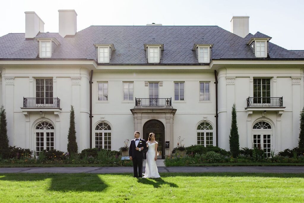 Wedding couple standing in front of Newfields Lilly House after their wedding ceremony.