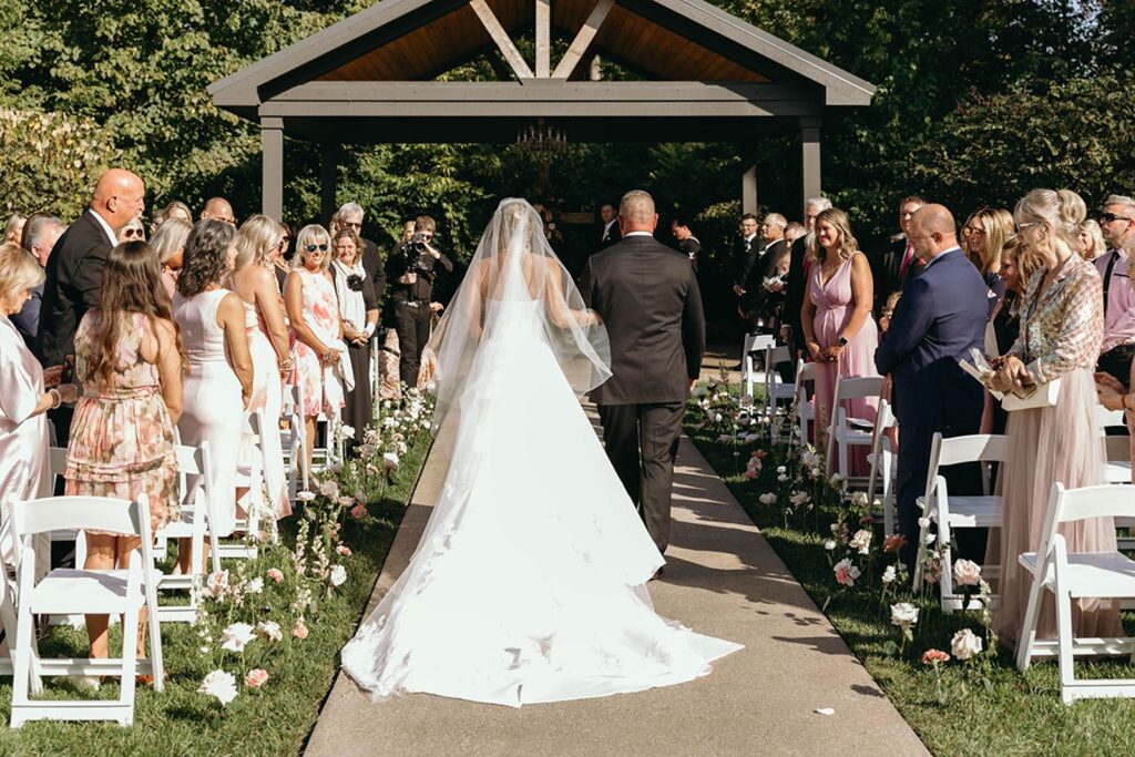 Wedding ceremony bride walking down aisle with her dad.