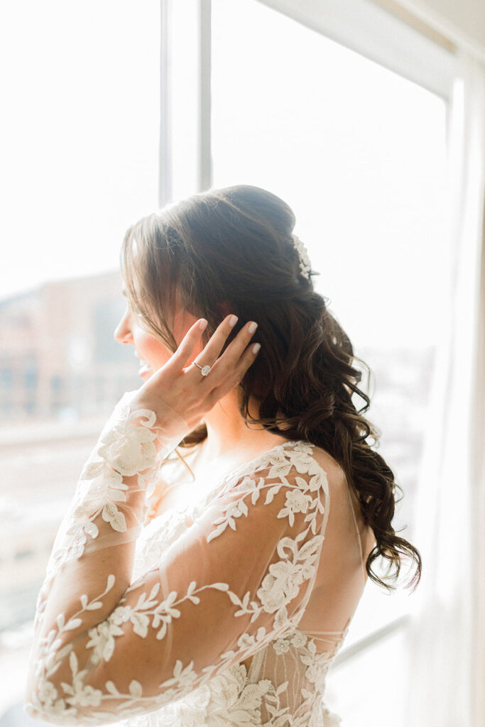 Bride posing next to window at Omni Severin bridal suite.