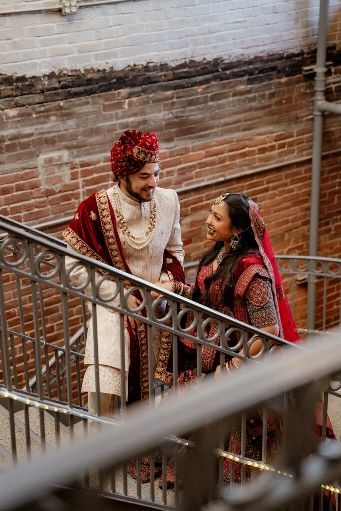 Maya and Jordan walking up stairs to their Sangeet Celebration at Mill Top Banquet Center